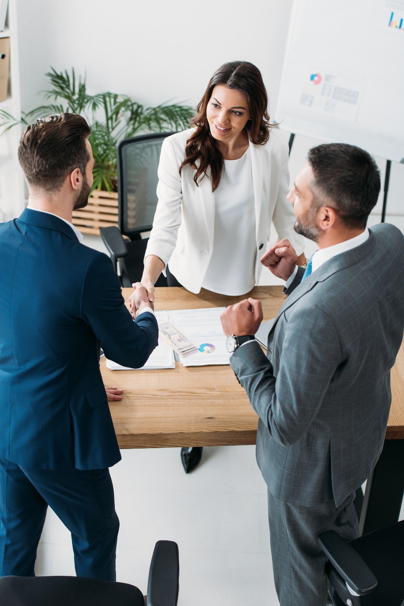 beautiful-advisor-and-handsome-investor-shaking-hands-at-workplace.jpg